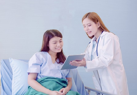 Beautiful smart Asian doctor and patient discussing and explaining